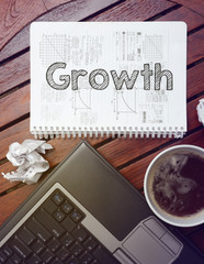 work place - table with notebook with note about: growth