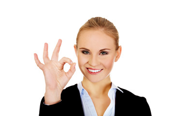 Young happy business woman shows OK sign