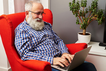 senior man working with laptop at home