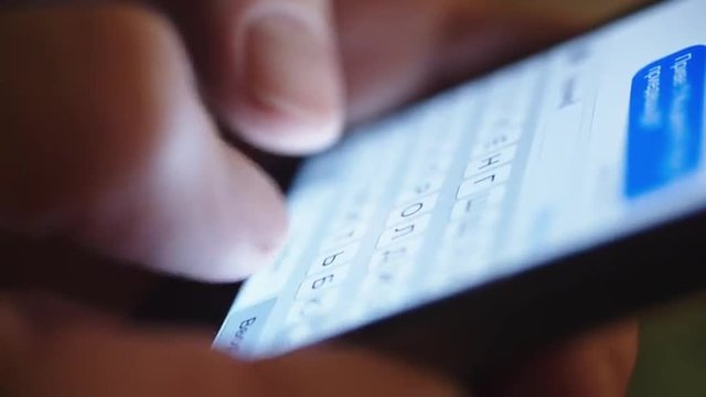 woman typing text on a smartphone, close-up