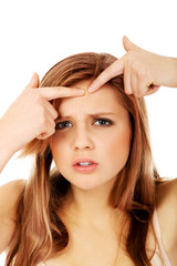 Fototapeta premium Teenage angry woman poping pimple