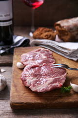 Marbled beef steak with bottle of wine and spices on wooden background