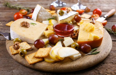 Different kinds of cheese on wooden background