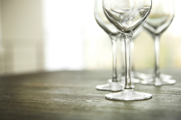 Empty wine glasses on wooden table against blurred background