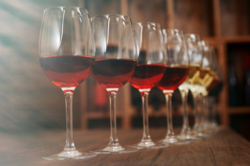 Many glasses of different wine in a row on bar counter