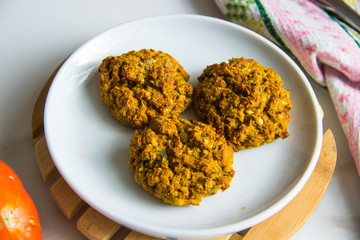 vegan lunch - burgers from lentils and carrots on the plate and tomatoes