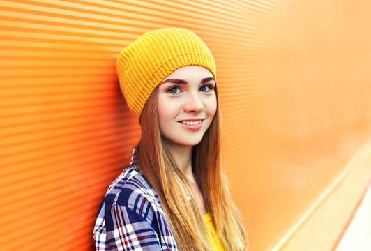 Portrait closeup beautiful young girl in yellow hat over colorfu