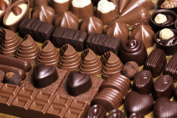 Delicious chocolate candies on wooden background