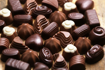 Assortment of delicious chocolate candies background, close up