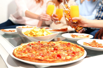Friends hands holding hot pizza, close up