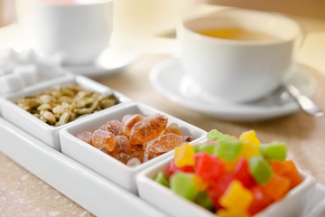 Set of candies and tea on table close up