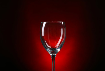 Empty wineglass on dark red background