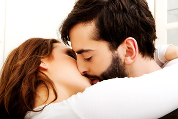 Happy beautiful couple kissing in the kitchen.