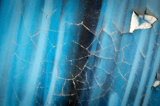 Mur peint en bleu avec d&eacute;but de fissure et morceaux de cr&eacute;pis en moins