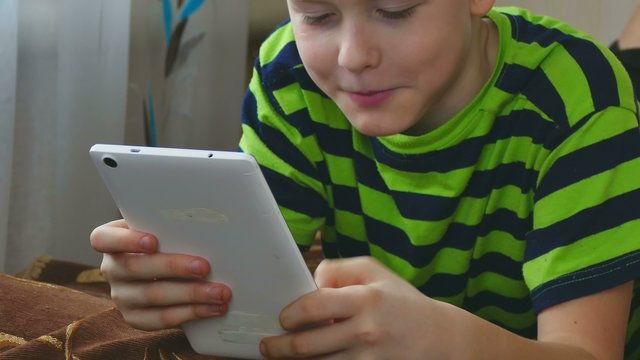 boy teenage  playing game on tablet internet browsing 