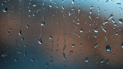 Beautiful blue abstract raindrop pattern on a window at day light. Lovely metal look effect used.