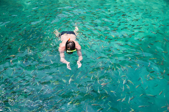 Man swims among the fish in the mask, Andaman Sea, Thailand