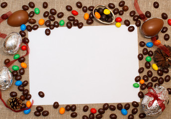 empty space for text in a frame of chocolate eggs. concept of tradition hunting for Easter eggs. chocolate eggs, candy, blank paper for your text on natural textile background