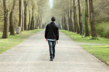 Teenage boy walking down a rural road - Powered by Adobe