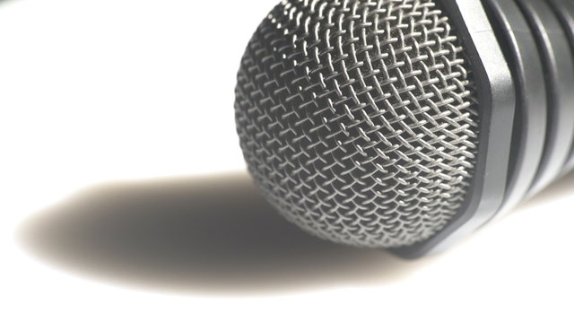 Macro view of a head of a classic handheld microphone steel grid turning left