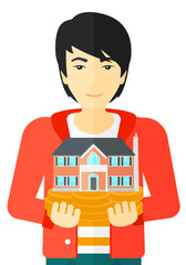 Man holding house model.