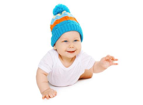 Happy Cute Smiling Baby In Knitted Hat Crawls On White Backgroun