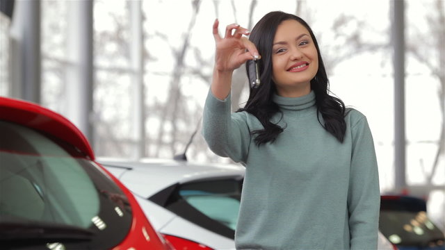 Smiling woman with car key outside