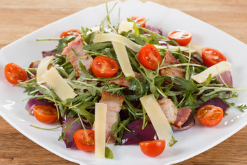 Fresh salad with bacon, tomatoes, parmesan and arugula