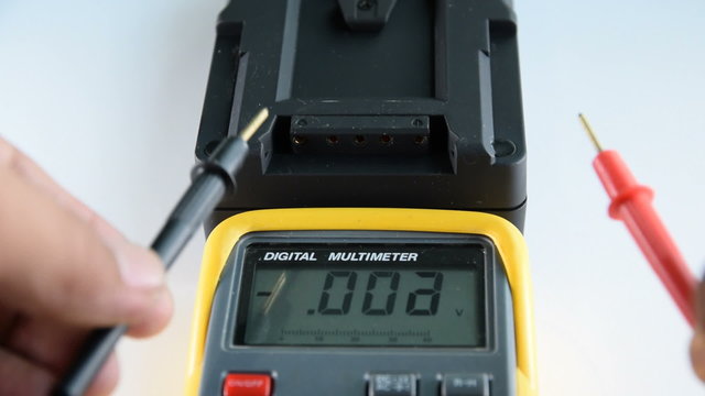 Measuring DC voltage of the battery with a digital meter.