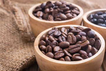 Various types of coffee beans in the wood bolw on the wooden table