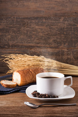 A coffee and bread with a soften light of morning background is texture of gain and wooden table, coffee concept