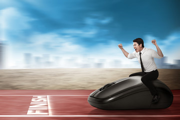 Asian business person riding computer mouse