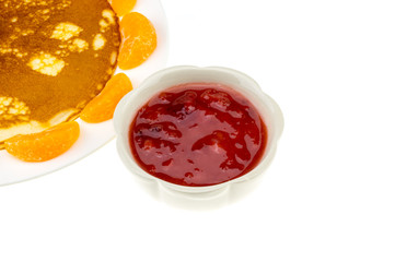 pancake and orange and strawberry sauce on white plate