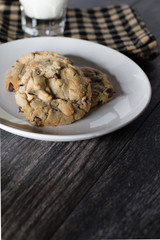 Chocolate chip cookies and milk served on a wood table