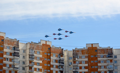 Пролет пилотажной группы из самолетов Су-27 и МиГ-29 над жилыми домами.  - obrazy, fototapety, plakaty