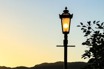 Vintage lamp post with sunset Background (sillhouette)