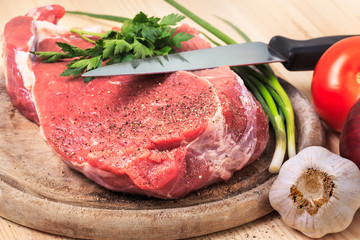Slice of meat on the cutting board with knife
