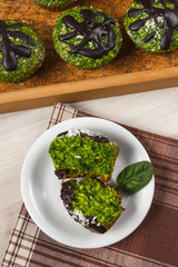 Fresh muffins with spinach, desiccated coconut and chocolate glaze, delicious healthy dessert