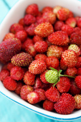 wild strawberries in an old clay bowl, top view