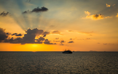 Naklejka na ściany i meble Scenery of the sea during sunset with ferry