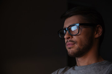 Obraz premium Handsome man in glasses looking at screen
