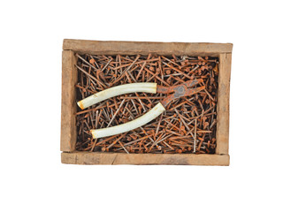 Rusty nail and wire cutter in wooden box, isolated on white background
