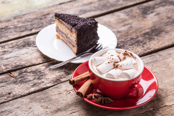 Hot cocoa with marshmallows and slice of cake