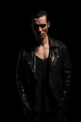 Obraz premium young biker in black leather posing with hands in pockets