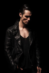 dark portrait of handsome rocker posing in studio background