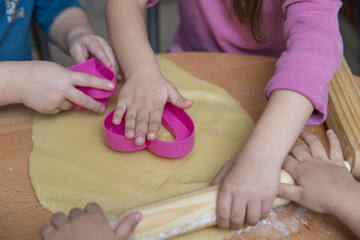 Obraz na płótnie Canvas Children hands rolling out dough