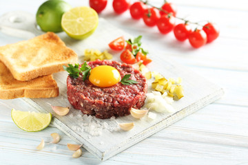 Beef tartare with egg yolk on a blue wooden table