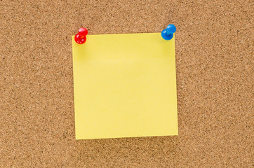Cork board with blank note attached with thumb pin
