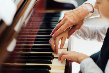 hand of an experienced pianist  helping young students