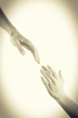Two hands reaching toward each other. Helping concept. Vintage tone